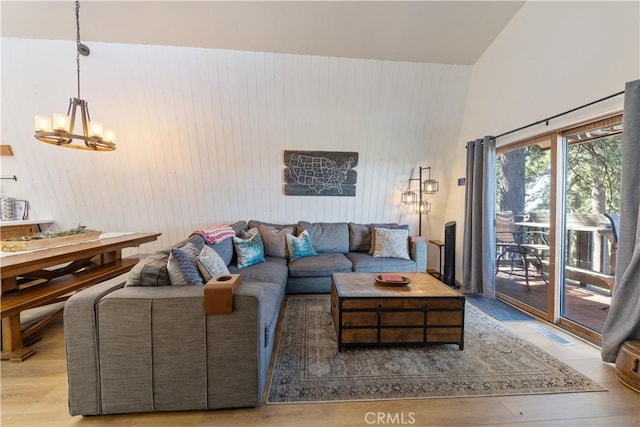 30897 Glen Oak Dr, Running Springs, CA 92382 - living area featuring a chandelier, a towering ceiling, wooden walls, and wood finished floors