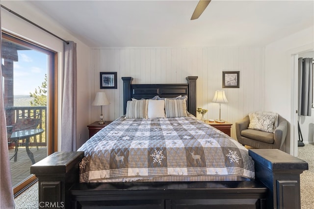 bedroom with wooden walls, carpet, ceiling fan, and access to outside