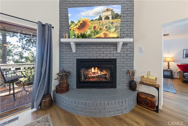 details with wood-type flooring and a brick fireplace