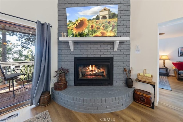 30897 Glen Oak Dr, Running Springs, CA 92382 - detailed view of wood finished floors, a brick fireplace, and baseboards