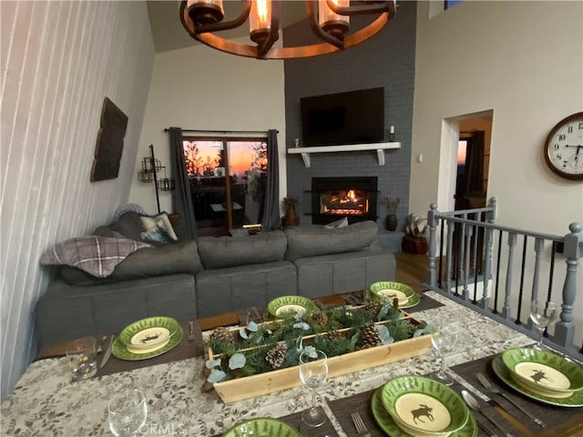 living room featuring wood-type flooring, a fireplace, and a notable chandelier