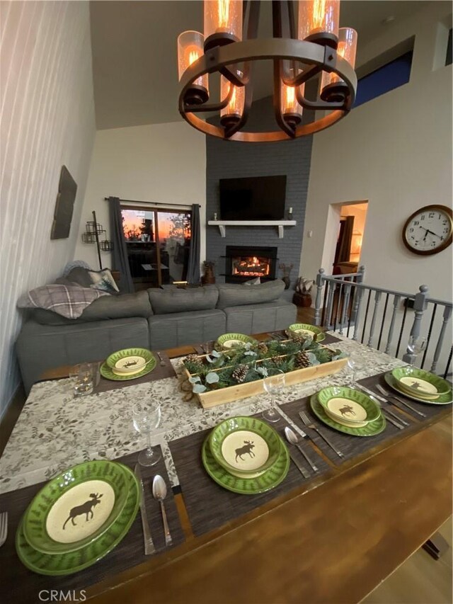 30897 Glen Oak Dr, Running Springs, CA 92382 - dining space with a large fireplace, a chandelier, and a towering ceiling