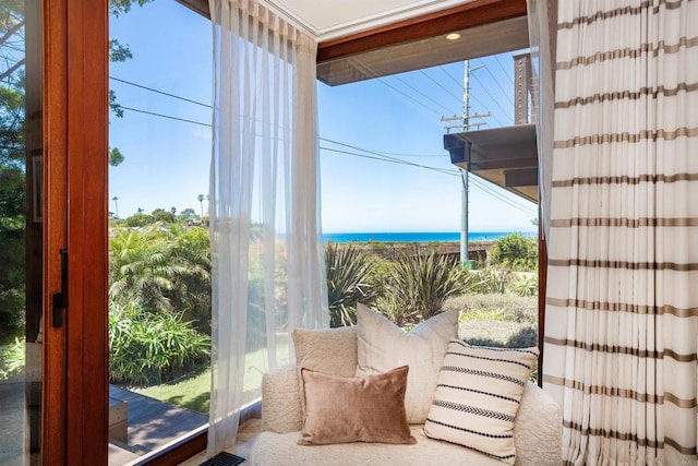 sunroom featuring a water view