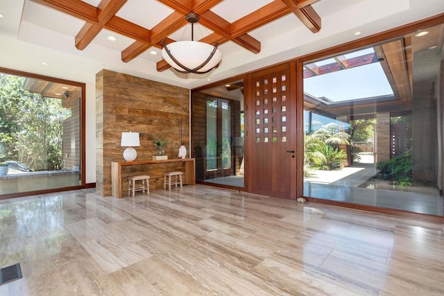 interior space with beamed ceiling, coffered ceiling, and a skylight