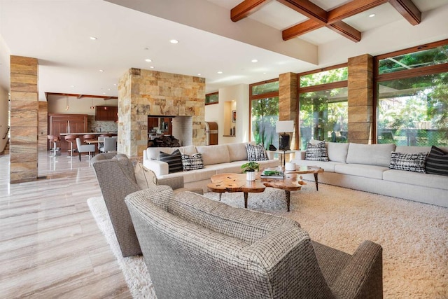 living room featuring light wood-type flooring, coffered ceiling, beam ceiling, and plenty of natural light