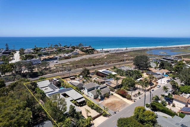 birds eye view of property with a water view and a beach view