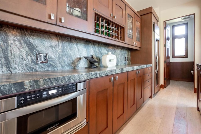 kitchen featuring appliances with stainless steel finishes, wood walls, and backsplash