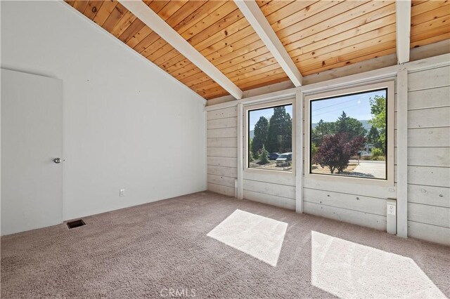 interior space featuring lofted ceiling with beams, wooden walls, wooden ceiling, and carpet flooring