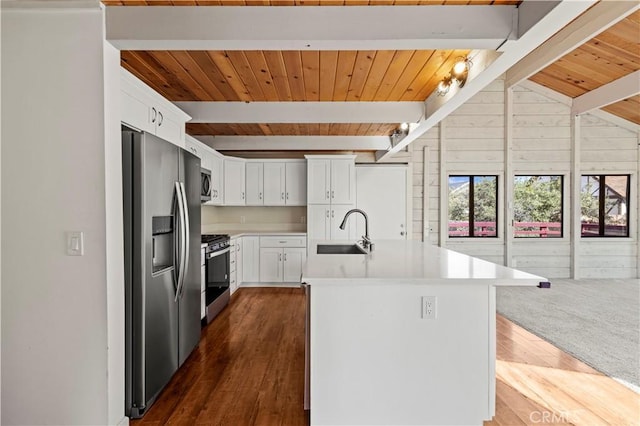 kitchen featuring beamed ceiling, dark wood-style floors, light countertops, a sink, and stainless steel appliances