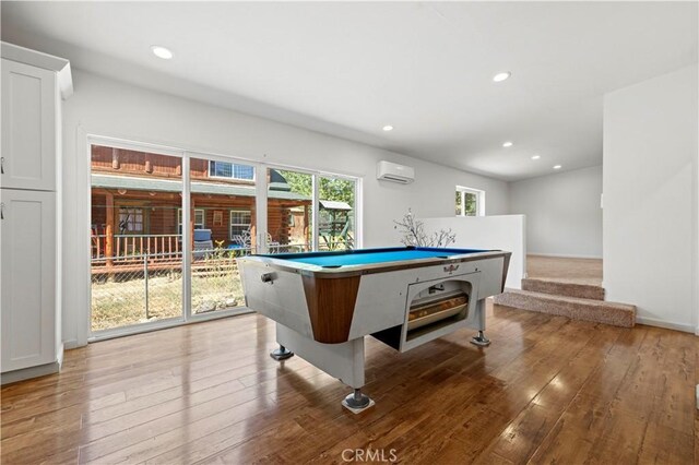 game room featuring a wall mounted air conditioner, pool table, and hardwood / wood-style floors