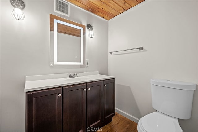 bathroom featuring wood-type flooring, wooden ceiling, vanity, and toilet