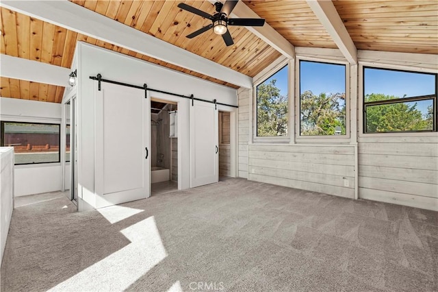 unfurnished bedroom with carpet, a barn door, wood ceiling, and multiple windows