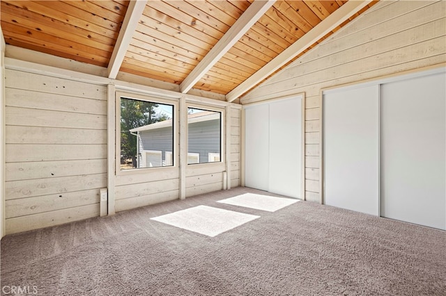 interior space with wooden walls, lofted ceiling with beams, carpet, and wooden ceiling