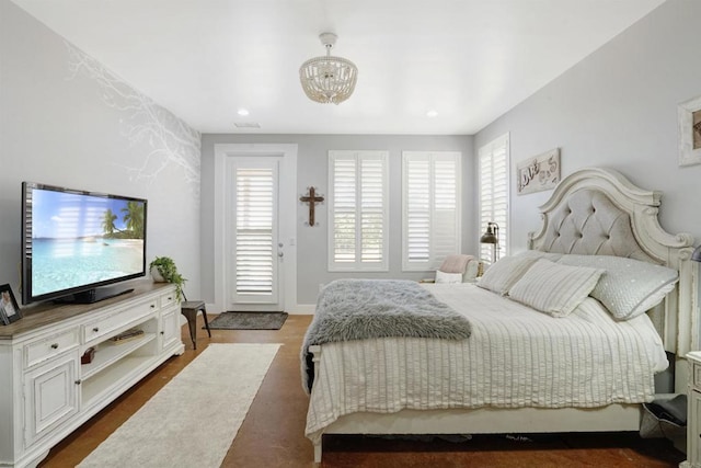 bedroom featuring multiple windows, a chandelier, and dark hardwood / wood-style floors