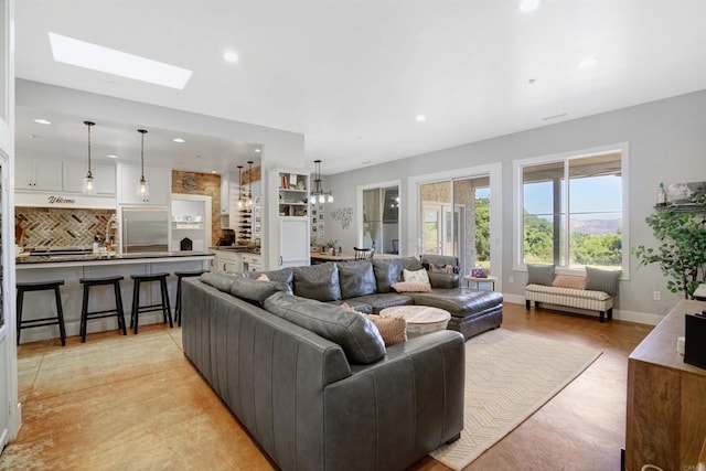 living room with a skylight and an inviting chandelier