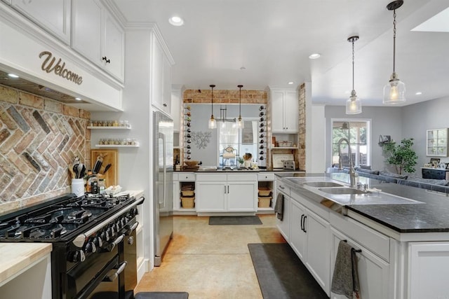 kitchen featuring white cabinets, high quality appliances, sink, and hanging light fixtures