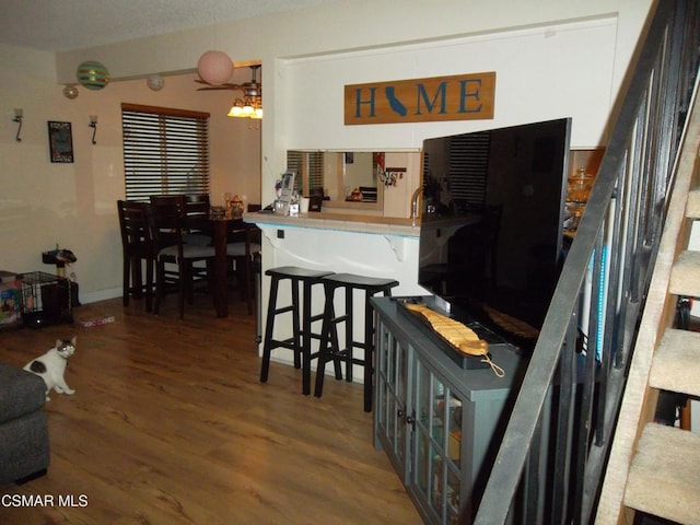 kitchen featuring kitchen peninsula, hardwood / wood-style flooring, and a breakfast bar area