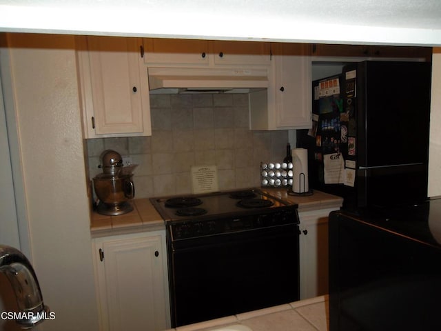 kitchen with white cabinets, decorative backsplash, tile counters, and black appliances