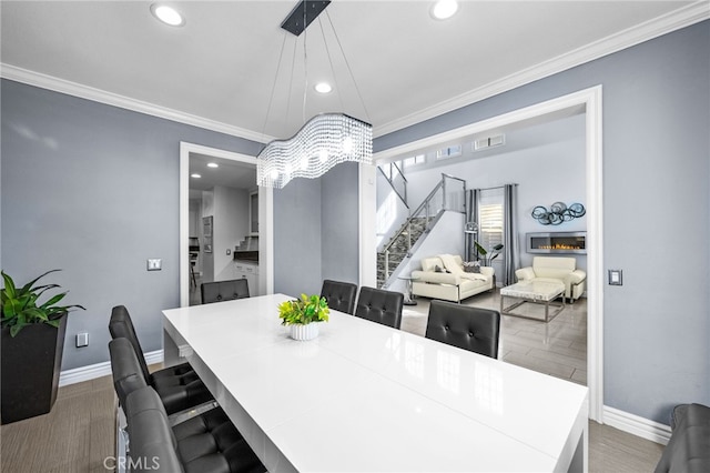 dining area with hardwood / wood-style flooring and crown molding