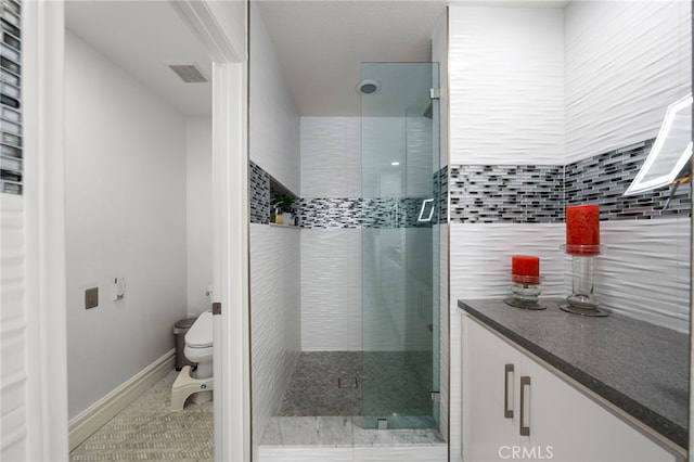 bathroom featuring tile patterned flooring, a shower with door, vanity, and toilet