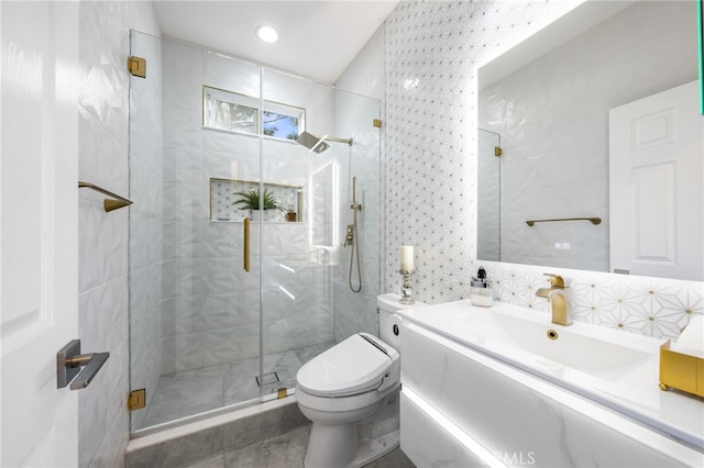 bathroom featuring walk in shower, tile walls, vanity, and toilet