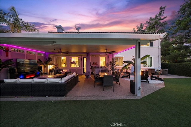 rear view of property featuring a patio, a yard, an outdoor living space, and ceiling fan