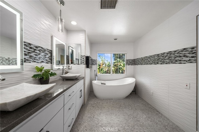 bathroom with vanity, tile walls, and a bathing tub