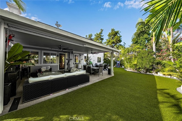 view of yard featuring an outdoor living space, ceiling fan, and a patio area