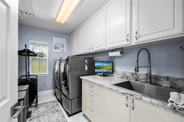 laundry area with cabinets, washer and dryer, and sink