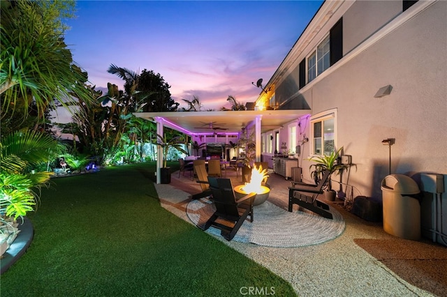 yard at dusk featuring a fire pit and a patio area