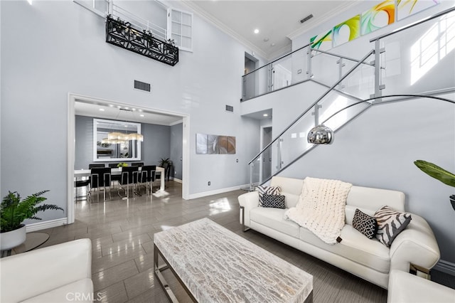 living room with ornamental molding, a high ceiling, and dark tile patterned floors