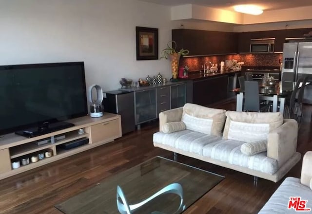 living room with sink and dark wood-type flooring