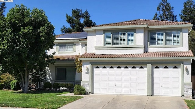 view of front of property with solar panels, a garage, and a front yard