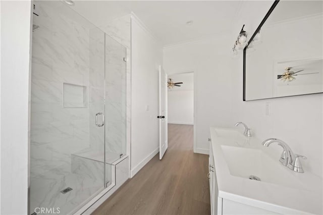 bathroom featuring hardwood / wood-style floors, vanity, ornamental molding, and walk in shower