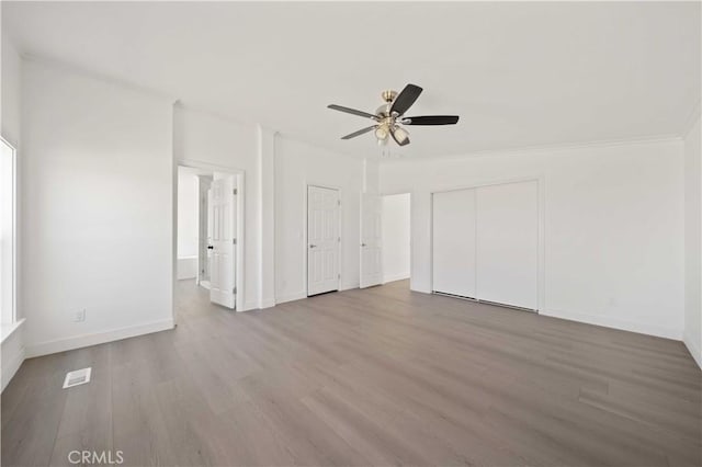 interior space with ceiling fan, ornamental molding, and hardwood / wood-style flooring