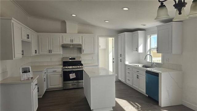 kitchen featuring white cabinetry, sink, decorative light fixtures, a kitchen island, and appliances with stainless steel finishes