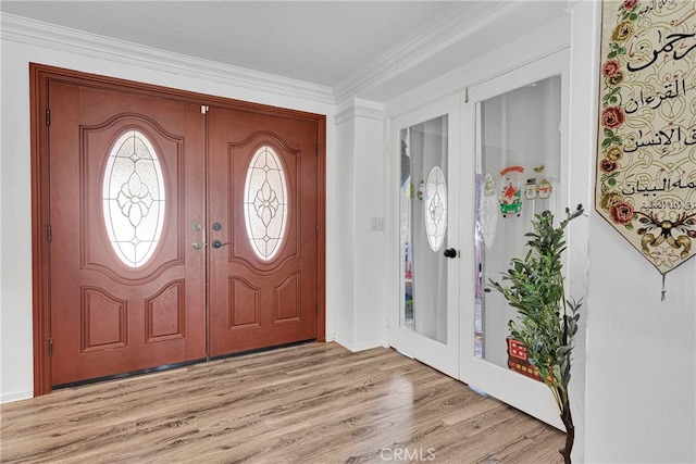 foyer featuring light hardwood / wood-style flooring and crown molding