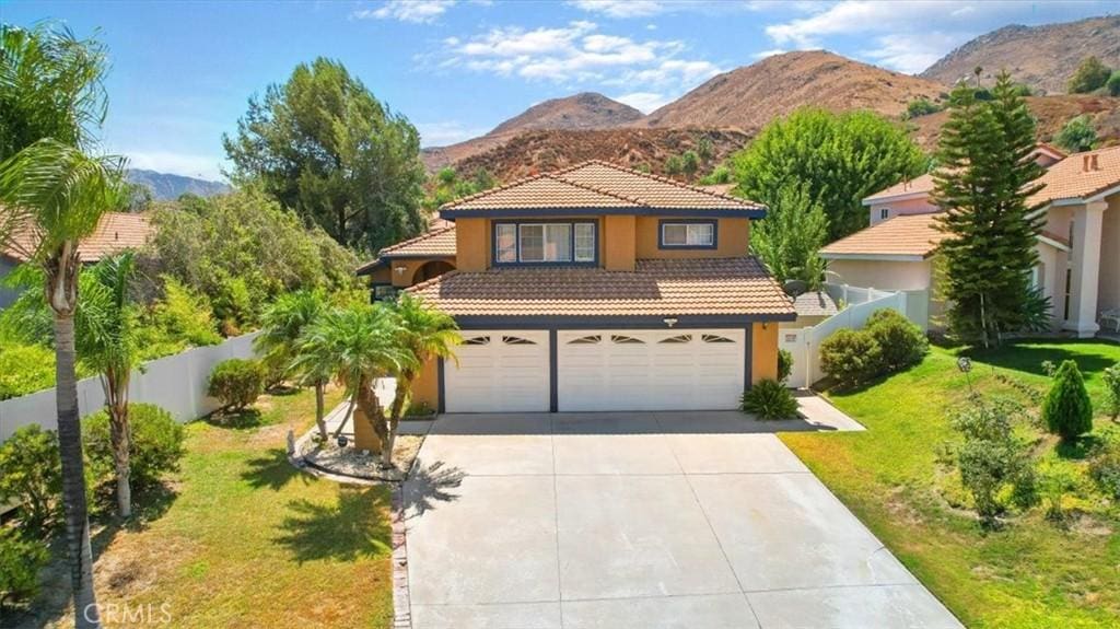 mediterranean / spanish home with a front yard, a garage, and a mountain view