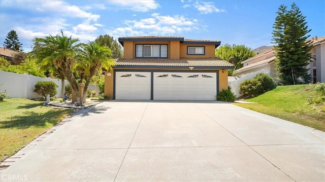 mediterranean / spanish home featuring a garage and a front lawn