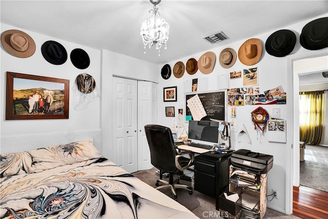 bedroom with a chandelier, dark carpet, and a closet