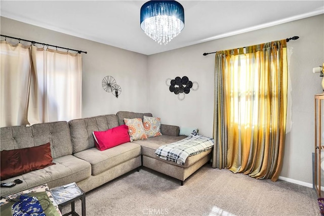 carpeted living room featuring a notable chandelier and plenty of natural light