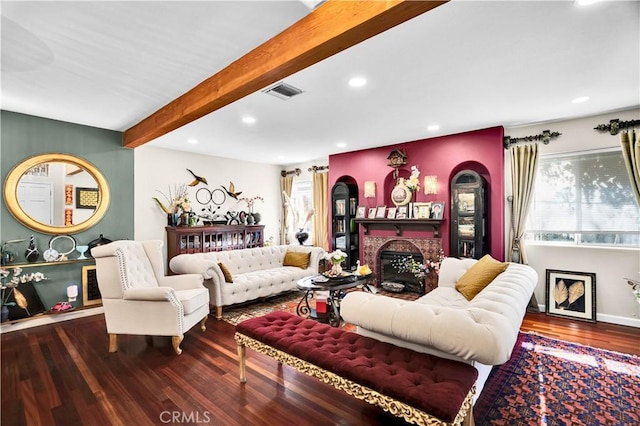 living room with beam ceiling, hardwood / wood-style flooring, and a brick fireplace