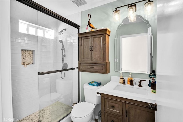 bathroom with walk in shower, vanity, and toilet