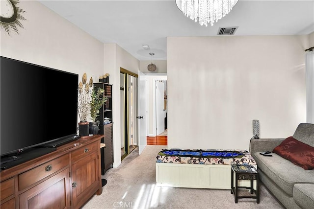 living room with light carpet and a chandelier