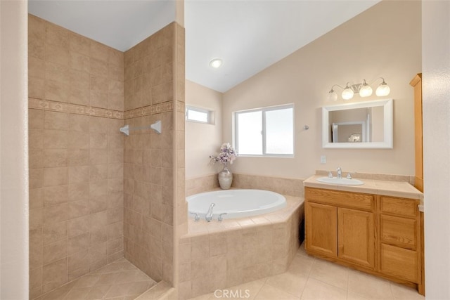 bathroom with tile patterned floors, tiled tub, vanity, and vaulted ceiling