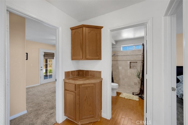 bathroom with toilet, wood-type flooring, and walk in shower