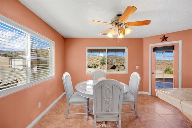 tiled dining space with ceiling fan and a textured ceiling