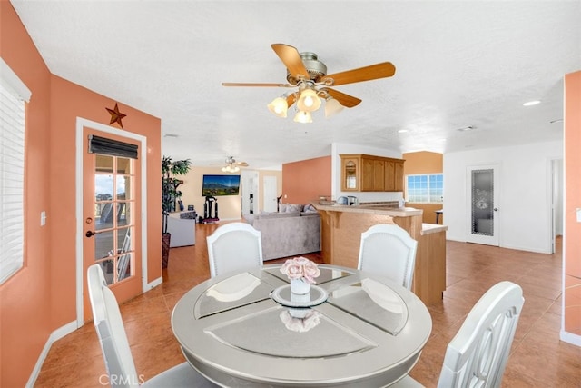 dining room featuring plenty of natural light, light tile patterned flooring, and a textured ceiling