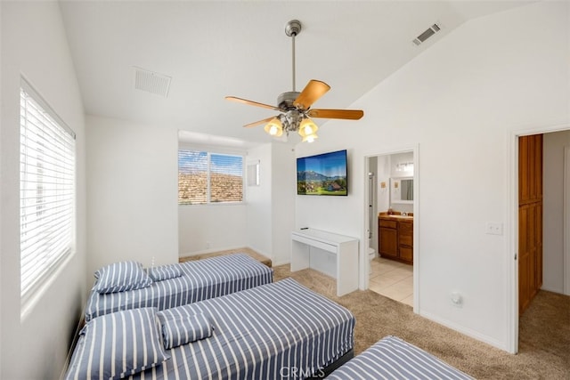 carpeted bedroom featuring ensuite bathroom, vaulted ceiling, multiple windows, and ceiling fan