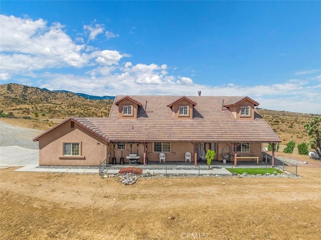 view of front of property featuring a mountain view and a patio